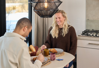 Zwei Personen frühstücken gemeinsam in der Happy Oak wellnesslodge im Ferienpark Mölke, Niederlande.