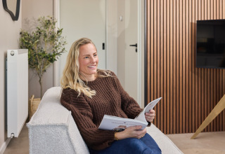Frau entspannt sich und liest ein Buch im Happy Oak wellnesslodge, Holiday park Mölke, Niederlande.