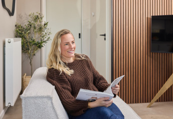 Frau entspannt sich und liest ein Buch im Happy Oak wellnesslodge, Holiday park Mölke, Niederlande.