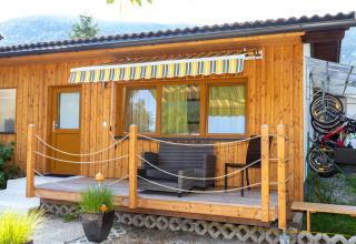 Hyggelig træbungalow med veranda, markise og cykler, set ved Blasge Bungalow 1 i Østrig.