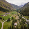 Aerial view of Huttopia Champagny and Vanoise holiday park in a scenic green valley in Auvergne-Rhône-Alpes.