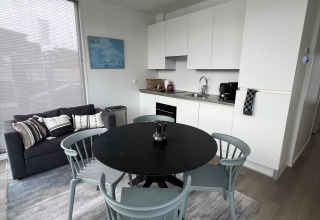 Sala de estar y cocina modernas en una casa flotante en Marina Lemmer, Países Bajos, con interior elegante.