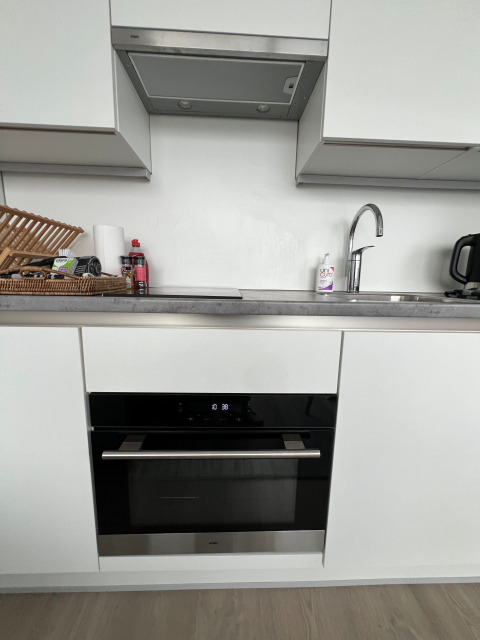 Cocina moderna con horno, fregadero, campana extractora y escurridor en una casa flotante en Marina Lemmer.