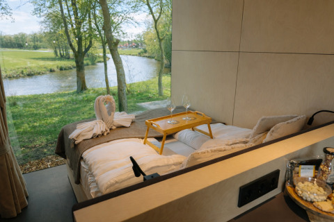 Uitzicht vanuit het bed in River Mirrorlodge bij Holiday park Mölke, met panoramisch uitzicht op de rivier.