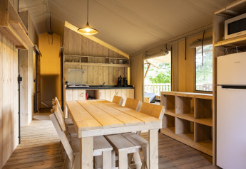 Binnenzicht van de Dreamer safaritent bij Arden Parks Signy l'Abbaye met houten keuken en eetruimte.