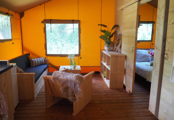 Interieur van een safaritent met houten meubilair bij Arden Parks in Signy l'Abbaye, Frankrijk.