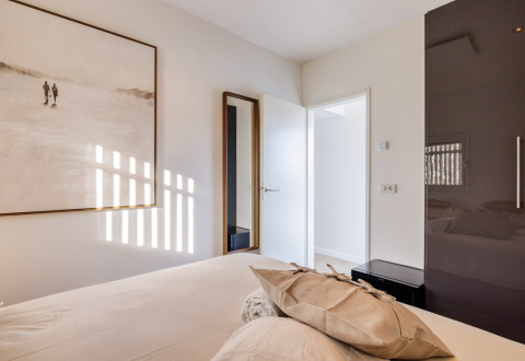 Modernes Schlafzimmer im Ferienpark Marina Lemmer in Friesland mit heller Einrichtung und großem Gemälde.
