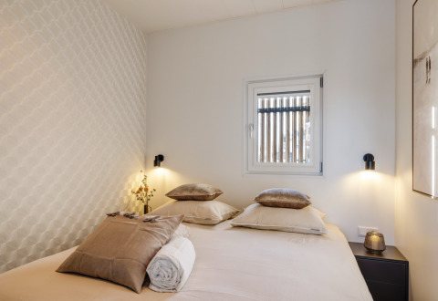 Dormitorio moderno con cama doble, ventana y luces suaves en Marina Lemmer, Friesland, Países Bajos.