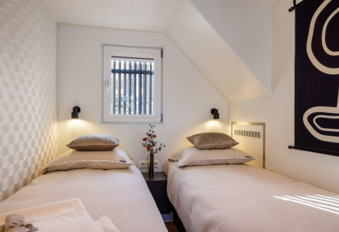 Moderne logeerkamer met twee eenpersoonsbedden en minimalistische inrichting bij Marina Lemmer in Friesland.