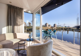 Lichte woonkamer met uitzicht op terras en water bij Marina Lemmer, vakantiepark in Friesland, Nederland.