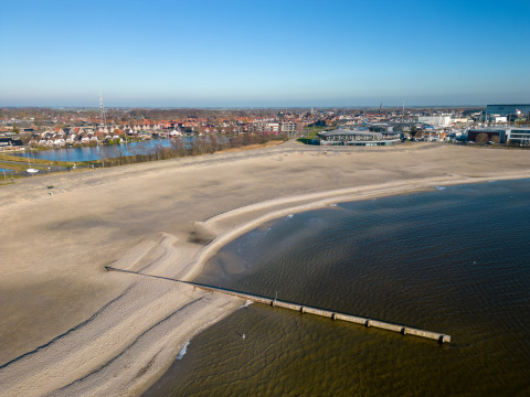 Vista aerea del parco vacanze Marina Lemmer in Frisia, Paesi Bassi, con spiaggia, mare e città vicina.