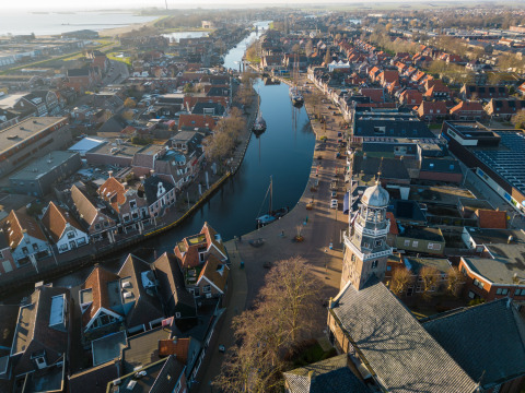 Vista aérea de Marina Lemmer en Friesland, Países Bajos, con canales, barcos y tejados tradicionales iluminados.