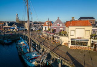 Boten aangemeerd bij Marina Lemmer in Friesland, Nederland, met cafés en historische panden aan het water.