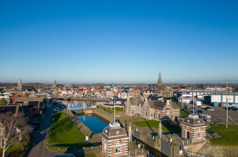 Luftfoto af Marina Lemmer feriepark i Friesland, Holland, med kanaler og historiske bygninger under blå himmel.