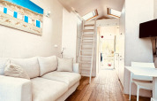 Intérieur moderne et lumineux d'une tiny house à Dishoek, Pays-Bas, avec canapé, bois et mezzanine.