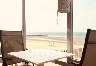 Due sedie e un tavolo su una terrazza con vista sulla spiaggia al Beach Sleep House Dishoek 37 a Zeeland.
