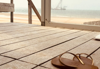 Una ciabatta marrone su un ponte di legno con vista sulla spiaggia e sul mare a Dishoek, Zeeland, Paesi Bassi.