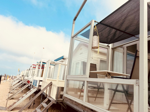 Casas en la playa con terrazas en Beach sleep house Dishoek 37, Zeeland, Países Bajos, en un día soleado.