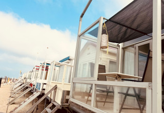 Row of modern beach cabins at Beach sleep house Dishoek 37, Zeeland, Netherlands, on a bright sunny morning.