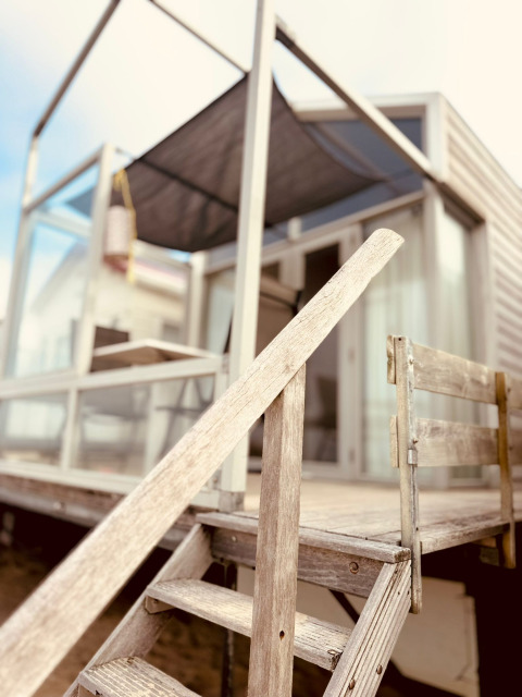 Tiny house da spiaggia in legno, Beach sleep house Dishoek 37, con veranda a Welcome In, Zeeland, Paesi Bassi.