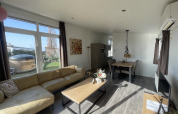 Séjour lumineux et moderne d’un lodge au Resort Mooi Bemelen, Pays-Bas, avec jardin et jacuzzi extérieur.