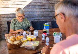 Ouder koppel ontbijt buiten met broodjes, eieren en koffie aan het Resort Mooi Bemelen in Nederland.