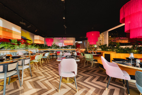 Moderne restaurantinteriør på Lodge Biesbosch, Resort Mooi Bemelen, med farverige stole og lamper.