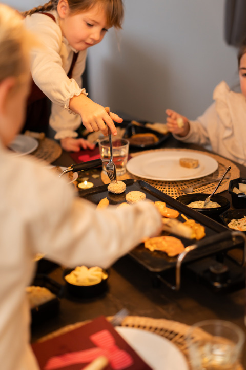 Kinderen koken en eten samen aan tafel in lodge Biebosch, Resort Mooi Bemelen, Nederland.