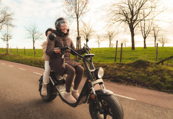 Twee mensen op een scooter langs een landelijke weg bij de Biebosch-lodge in Resort Mooi Bemelen, Nederland.