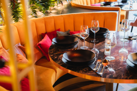Table élégante dressée avec assiettes noires et verres à Biebosch - Sunshower, Resort Mooi Bemelen, Pays-Bas.