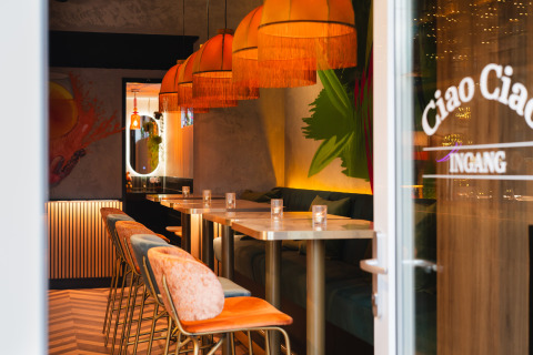 Inkijk in een trendy lodge met warme lampen, kleurrijke stoelen en gezellige, moderne inrichting.