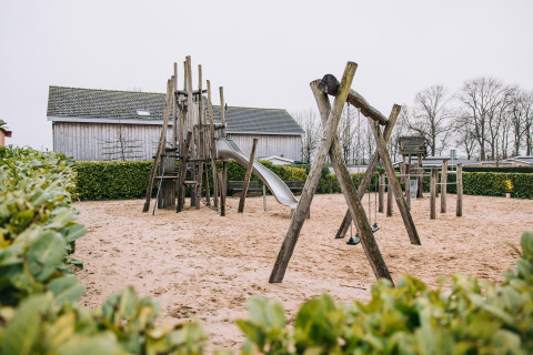 Aire de jeux avec structure en bois, toboggan et balançoires à la lodge Biebosch, Resort Mooi Bemelen, Pays-Bas.