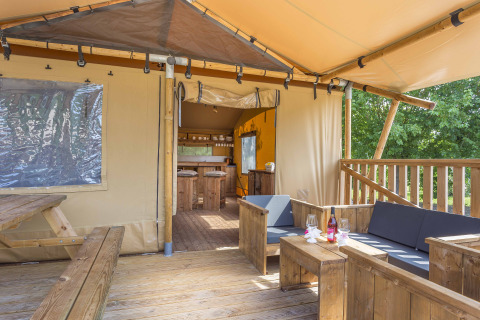 Tienda safari en Dune Agriturismo, Italia, con muebles de madera y terraza al aire libre cómoda