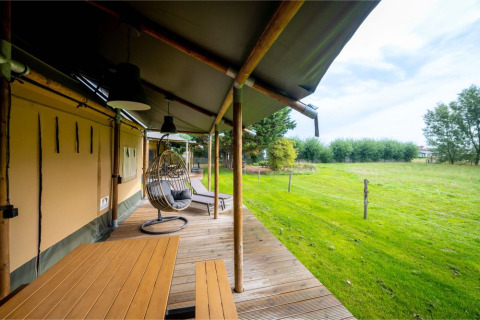 Die Safari-Lodge 'Nomad Family' im Holiday Village Knokke, Belgien, mit Veranda und Blick aufs Grüne.
