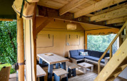 Interior of ‘Nomad Family’ safari tent at Holiday Village Knokke, Belgium, showing wood furniture and seating area.