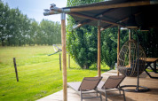 Außenbereich des Safari-Zeltes „Nomad Family“ im Holiday Village Knokke, Belgien, mit Liegestühlen und Hängesessel.
