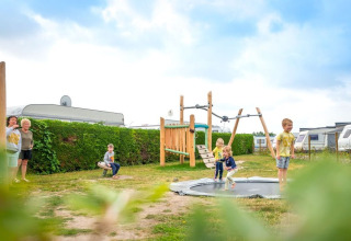 Enfants jouant sur une aire de jeux près de caravanes au Holiday Village Knokke, Flandre occidentale, Belgique.