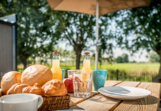 Desayuno al aire libre con panecillos, croissants y jugo en Holiday Village Knokke, Flandes Occidental.