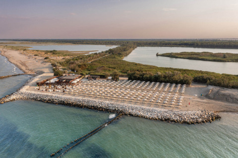 Aerial view of a beach with umbrellas and a beach club near Lido di Spina, Emilia-Romagna, Italy.