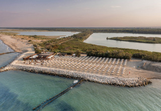Vista aerea di una spiaggia con ombrelloni e stabilimento vicino a Lido di Spina, Emilia-Romagna, Italia.