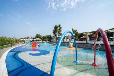 Kid-friendly pool area with water features and play structures at Spina Family Collection campsite in Emilia-Romagna, Italy.
