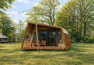 Safari-teltet Tribe lodgetent på Holiday park Mölke i Holland, omgivet af grønne træer og natur.
