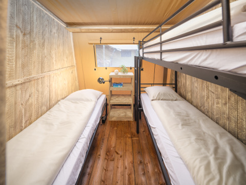 Interior del Tribe lodgetent en Holiday park Mölke, Países Bajos, con literas y paredes de madera.