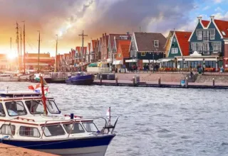 Casas coloridas y barcos en la ribera de Marina Uitgeest, parque vacacional en Holanda Septentrional, Países Bajos.