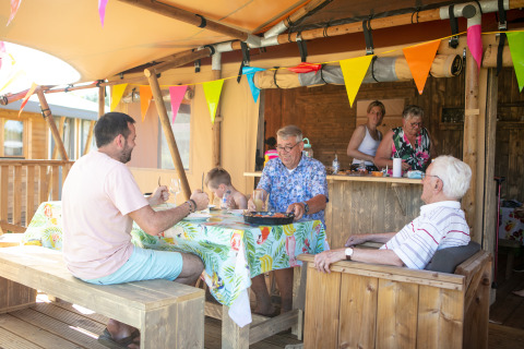 Familie nyder et måltid sammen i en luksus safaritelte på campingpladsen 't Veld i Holland.