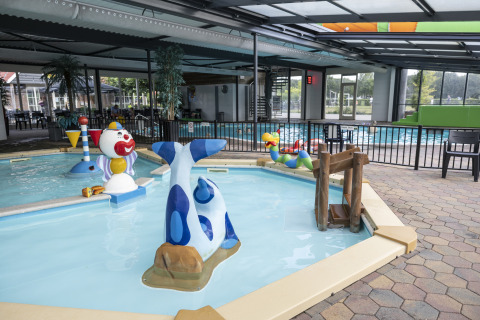 Piscina interior para niños con figuras acuáticas coloridas en Safari tent «de luxe» en Camping 't Veld, Países Bajos.