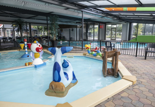 Piscina interior para niños con figuras acuáticas coloridas en Safari tent «de luxe» en Camping 't Veld, Países Bajos.