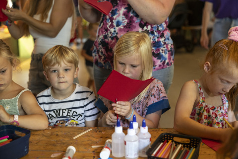 Kinderen knutselen met papier en lijm tijdens een verblijf op een glamping accommodatie.