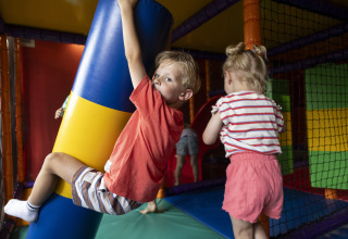 Niños juegan en un área de juegos interior en el Beach Chalet del Camping 't Veld en los Países Bajos.