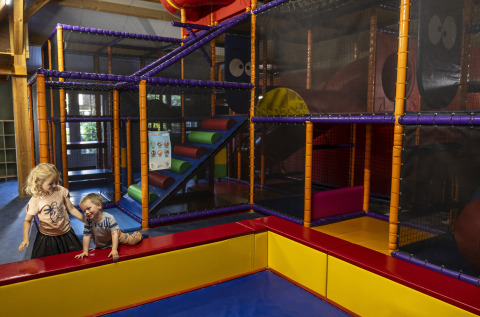 Kids playing in an indoor playground at the Beach house with hottub at Campsite 't Veld, Netherlands.